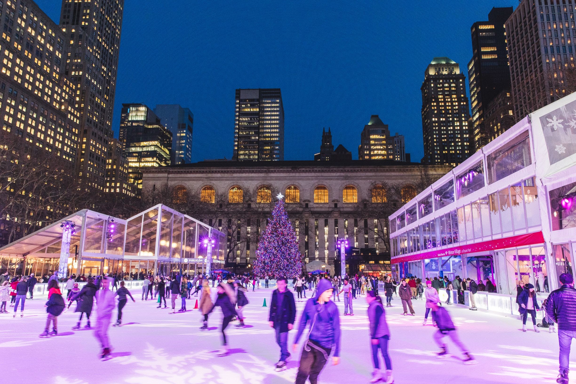 Ice skaters on the Winter Village rink in Bryant Park in the evening is one of the best things to do during Christmas in NYC