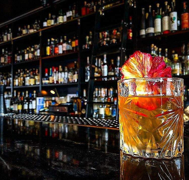 Cocktail in rocks glass sitting on a black marble bar in Reno, Nevada.