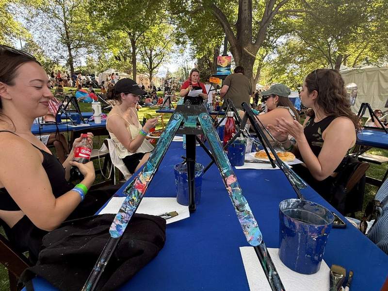 Girls sitting outside at a long table with easels at a park in Reno.