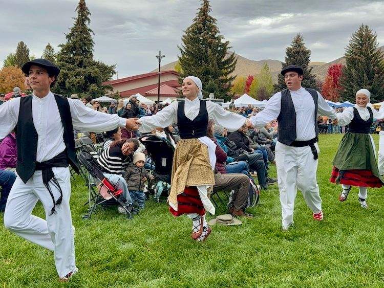 Group of traditional Basque dancers in vibrant costumes performing at the outdoor Folklife Fair in Hailey, Idaho.