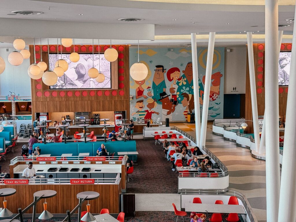 Food court at Cabana Bay Beach Resort with colorful mural in the background and teal and orange decor.