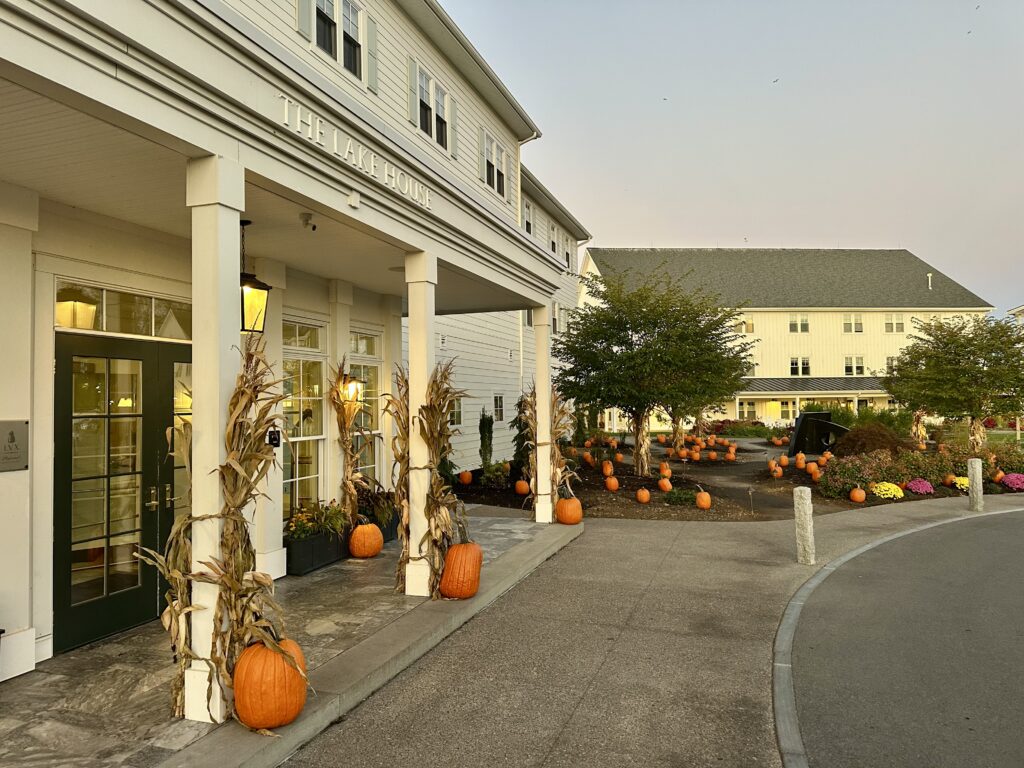 Front entrance of the Lake House on Canandaigua, a Finger Lakes resort, decorated with pumpkins, corn stalks and colorful mums for fall.