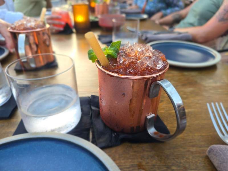 Moscow mule with sugar cane in a copper mug