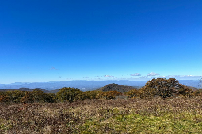 Blue skies and mountainside greenery beginning to turn into fall colors.