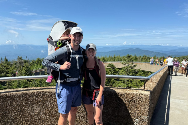 A family posing on a concrete trail bridge while on a mountain hike.