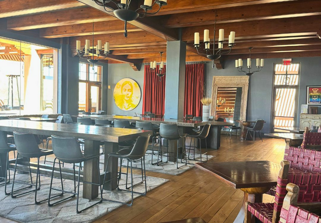 Interior of Talavera restaurant with dark wood furniture, modern chandeliers, red curtains, and Southwestern decor at Four Seasons Scottsdale