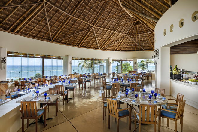 Restaurant with brown chairs, blue glasses and ocean views at Grand Velas family all-inclusive, Riviera Maya Mexico
