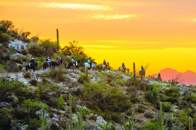 Horseback riding at sunset, when the rose and orange colors light up the desert and mountains at Tanque Verde Ranch.