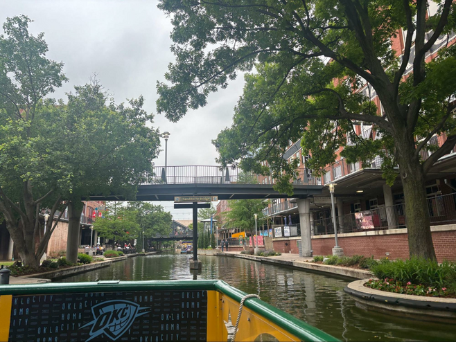 Canal with bridge and aligned with brick building on either side.