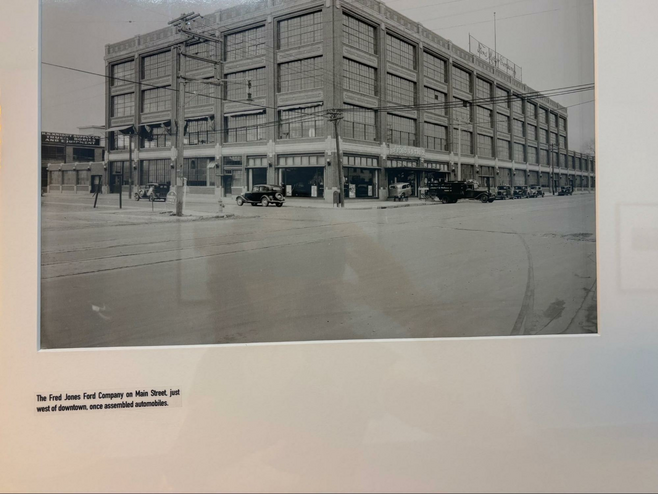 Historic phot of a building with lots of windows and cars from the early 1900's.