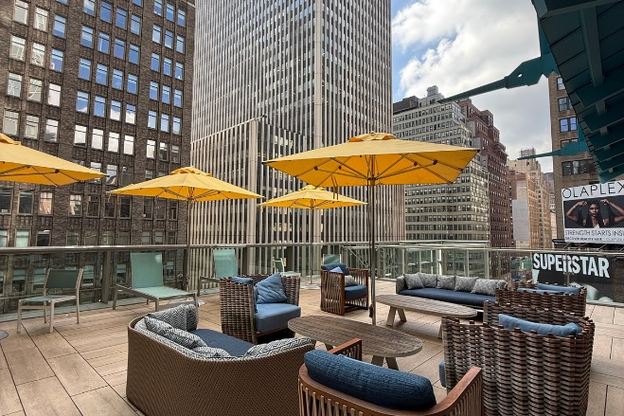 Landshark Bar & Grill: outdoor seating with yellow umbrellas & view of NYC skyline.