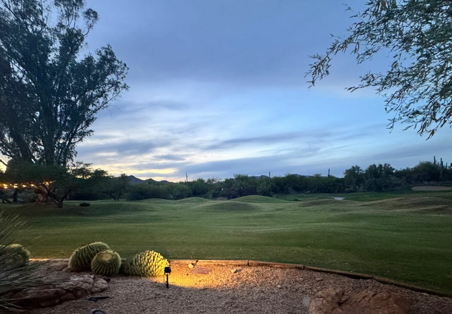 a golf course with rolling hills at dusk
