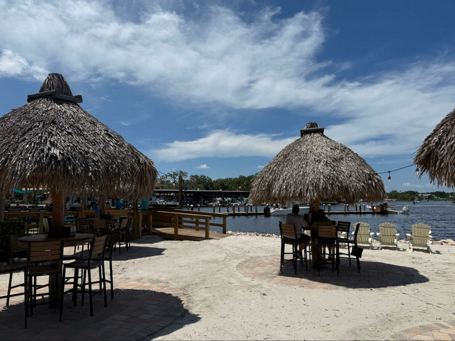 Tiki motif tables on the beach at Crump's Landing for lunch in Florida.