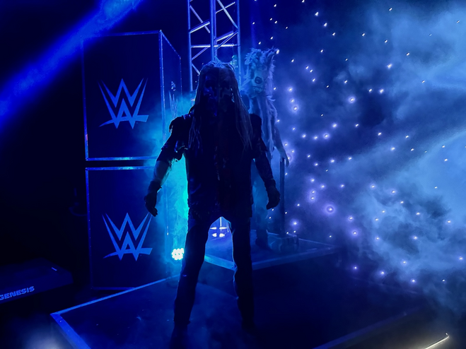 A man with a bird mask and long hair in a haunted house.