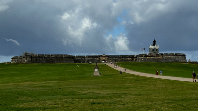 Green grass and a long castle made out of brick.