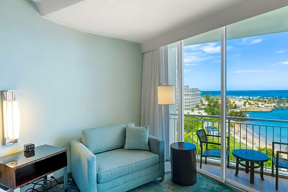 Furniture in a hotel room at Hotel Caribe in Puerto Rico with a view of the beach.