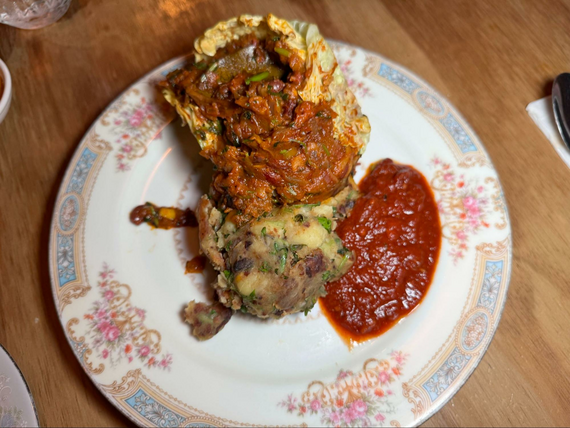 Vegetables and potatoes on a intricate dinner plate.