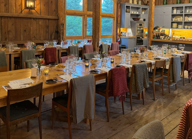 A dining room with tables set inside a barn